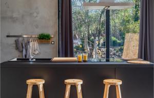 a kitchen with a counter with stools and a window at Gorgeous Home In Katuni With Wifi in Katuni