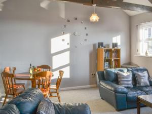 ein Wohnzimmer mit einem blauen Sofa und einem Tisch in der Unterkunft Smugglers Retreat in Woodhorn