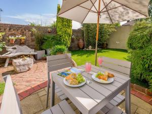 a table with two plates of food and an umbrella at Number 1 Admiralty Cottages in Alverstoke