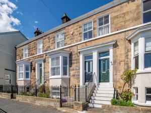 a brick house with a green door on a street at Edenholme in Robin Hood's Bay