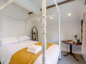 a bedroom with a white bed and a table at Gardeners Cottage - Uk35774 in Fulbeck
