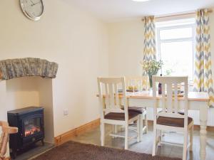 a dining room with a table and a fireplace at Typicca Farmhouse in Brechfa