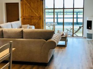 a living room with a couch and a large window at Mac Shack Cottage in Ashen