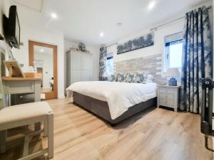 a bedroom with a bed and a wooden floor at Mac Shack Cottage in Ashen