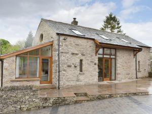 an old stone cottage with glass doors and windows at Stallion Barn in Crosby Garrett