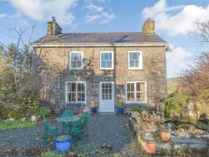 a brick house with a table and chairs in front of it at Pen Y Crug in Beulah