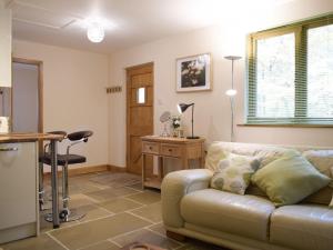 - un salon avec un canapé et une table dans l'établissement Oak Lodge, à Edwin Loach