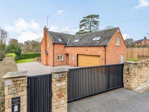 a brick house with a gate and a garage at The Continent in Ticknall