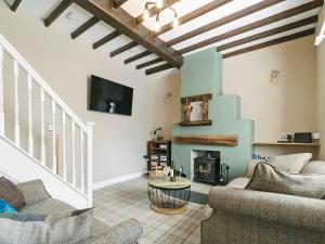 Pinfold Cottage في ريتشموند: غرفة معيشة مع كنبتين ومدفأة