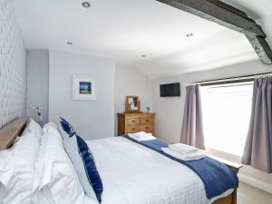 a bedroom with a large bed and a window at Pinfold Cottage in Richmond