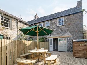 a picnic table with an umbrella in front of a building at Pinfold Cottage in Richmond