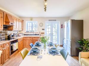 una cucina con tavolo e frigorifero di Lilium Cottage a North Somercotes