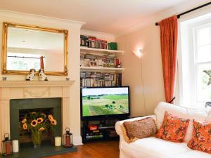 a living room with a white couch and a television at Buckshaw Gate in Holwell