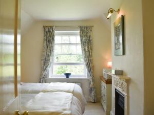 een slaapkamer met een bed en een raam bij Buckshaw Gate in Holwell