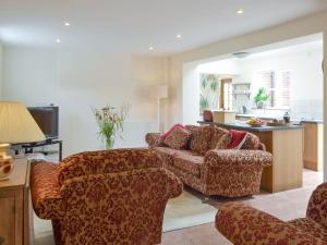 ein Wohnzimmer mit 2 Stühlen und einem Sofa in der Unterkunft The Coach House in Great Ryburgh