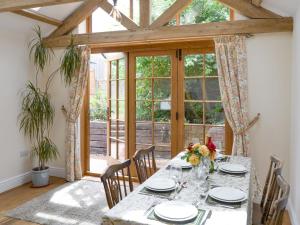 een eetkamer met een tafel en stoelen en een raam bij The Coach House in Great Ryburgh