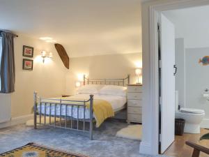 1 dormitorio con 1 cama y baño con aseo en Stables End, en Nettlecombe