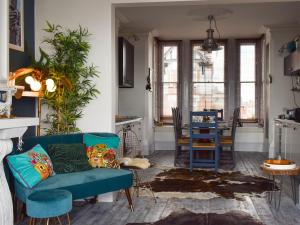 sala de estar con sofá azul y mesa en Fronks House en Harwich