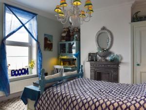 Schlafzimmer mit einem Bett, einem Spiegel und einem Fenster in der Unterkunft Fronks House in Harwich