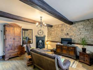 a living room with leather furniture and a stone wall at The Miners Rest in Middleton