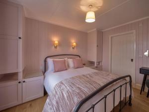 UigにあるUig Bay Cottageのベッドルーム1室(ピンクの枕が付いた大型ベッド1台付)