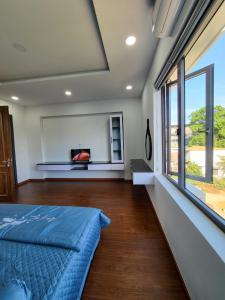 a bedroom with a bed and a large window at T Home BMT in Buon Ma Thuot