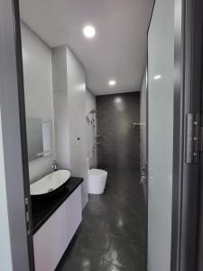 a white bathroom with a sink and a toilet at T Home BMT in Buon Ma Thuot