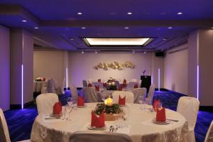 una sala de banquetes con mesas blancas y sillas blancas en Minamisenri Crystal Hotel en Suita