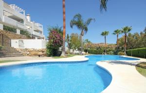 Bahia de CasaresにあるNice Home In Bahia De Casares With House A Mountain Viewのヤシの木が茂る家の前のスイミングプール