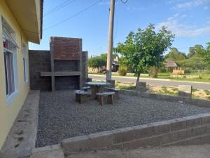 a picnic table and two benches next to a building at El Atardecer in Cortaderas
