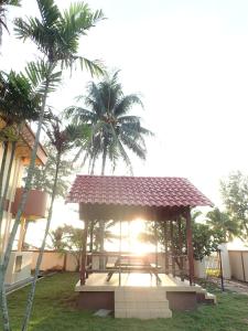 a gazebo with palm trees in front of a building at Seri Indah Resort in Kuala Terengganu
