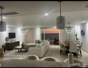 Marbella Juan dolio beach front luxury apartment في خوان دوليو: غرفة معيشة بأثاث أبيض وإطلالة على المحيط