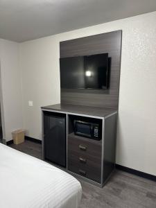 a hotel room with a tv and a bed at Sleepy Traveler Motel in Wagoner