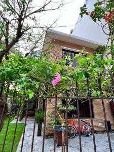 a pink flower on a tree in front of a house at Nhà An Cozy in Da Lat