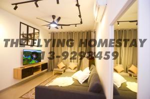 ein Wohnzimmer mit einem Sofa und einem TV in der Unterkunft The Flying Homestay Terengganu in Kuala Terengganu