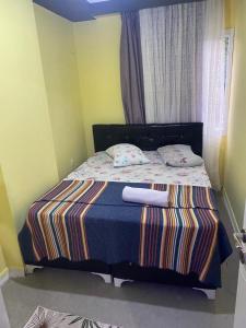 ein Bett mit einer gestreiften Decke und zwei Kissen darauf in der Unterkunft İmperyum otel in Kaleköy