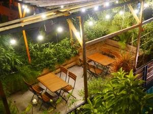 Cửa Biển Homestay في هاي فونج: فناء به طاولات وكراسي ونباتات في الليل