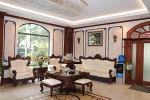 Halong Boutique Hotel في ها لونغ: غرفة معيشة مع كراسي وطاولة