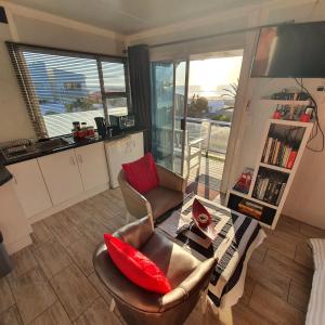 sala de estar con sofá y mesa en Atlantic Studio - Compact unit with Sea Views, en Melkbosstrand