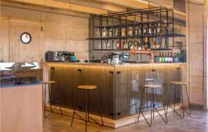 a bar with stools in a room with wooden walls at Cozy Home In Jezierzany With Sauna in Jezierzany