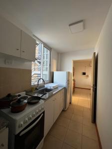 a kitchen with a stove and a refrigerator at Departamento San Luis Centro in San Luis