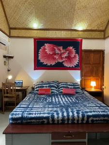 ein Schlafzimmer mit einem großen Bett mit zwei roten Kissen in der Unterkunft Mango House in Ko Lanta