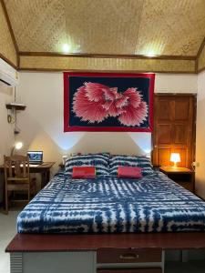a bedroom with a large bed with two red pillows at Mango House in Ko Lanta