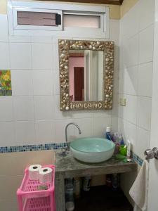 ein Bad mit einem Waschbecken und einem Spiegel in der Unterkunft Mango House in Ko Lanta