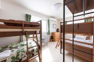 a bedroom with two bunk beds and a bathroom at niseko / Vacation STAY 4376 in Niseko