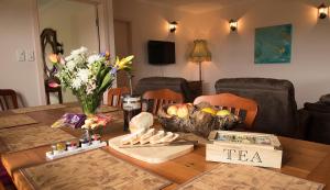a dining room table with a wooden table with food on it at Hill Cottage Hahndorf in Hahndorf +4 photos