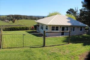 een huis met een hek ervoor bij Hill Cottage Hahndorf in Hahndorf