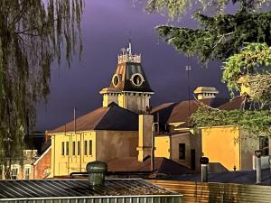 un gran edificio amarillo con una torre de reloj en The Brown House Tenterfield en Tenterfield