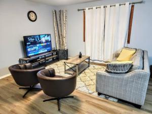 sala de estar con 2 sillas y TV en Riviera Beach Getaway with 5BDR near Airport and Casino en Pasadena