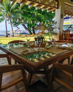 een tafel met wijnglazen en uitzicht op het strand bij Pura Vida Beach & Dive Resort in Dauin